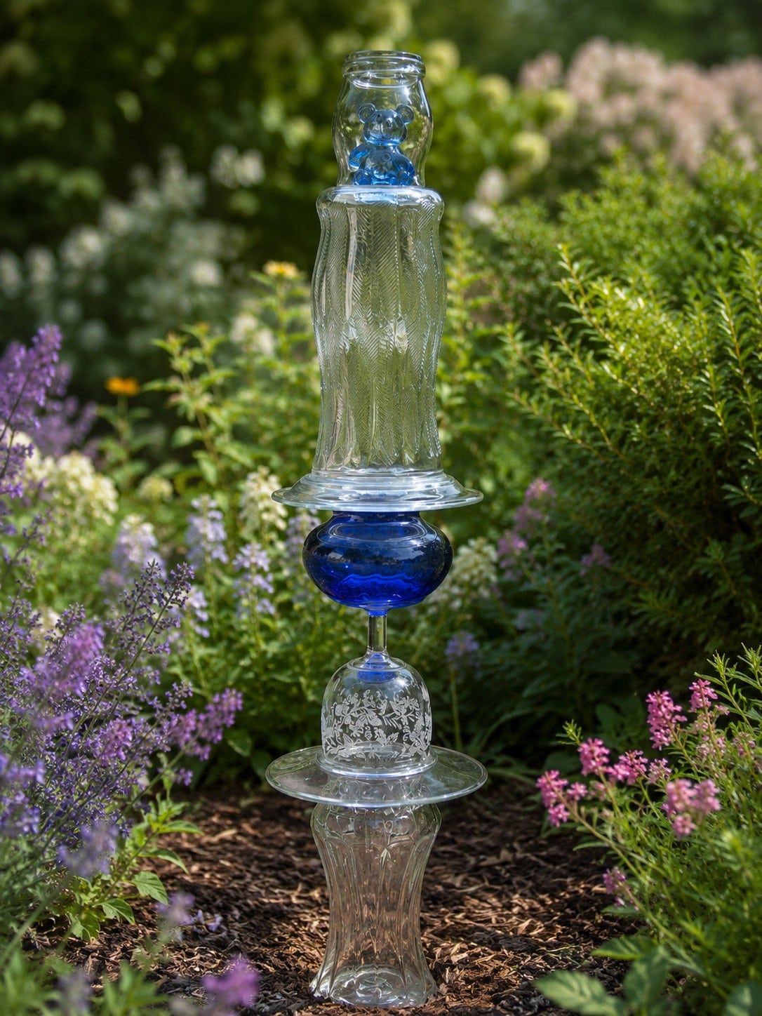 clear and blue glass topiary with a bear inside a vase