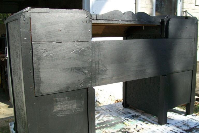 back of desk showing a large board in place to reassemble the desk