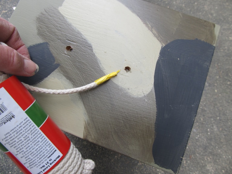threading rope into hole on drawer with painters tape on the end of the rope
