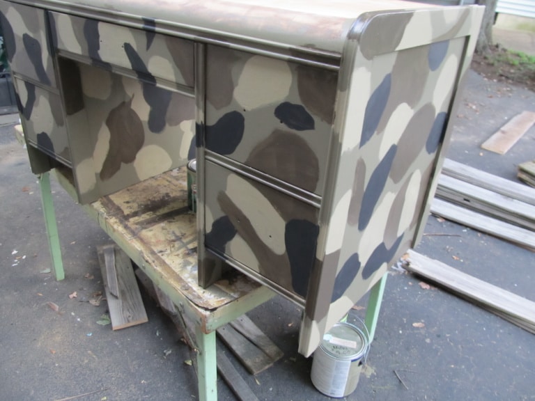 painting a camouflage desk atop a table