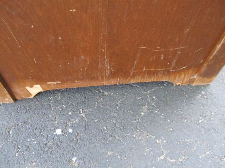 side of desk with damaged veneer