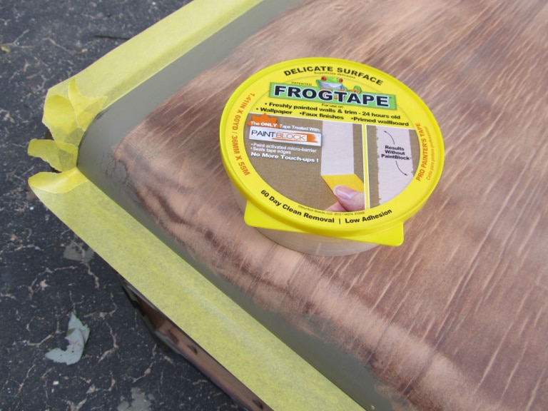 yellow frog tape on edge of desk so the top can be painted