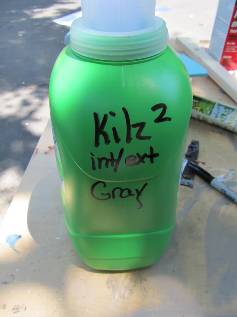 green laundry jug with sharpie marking the type of paint