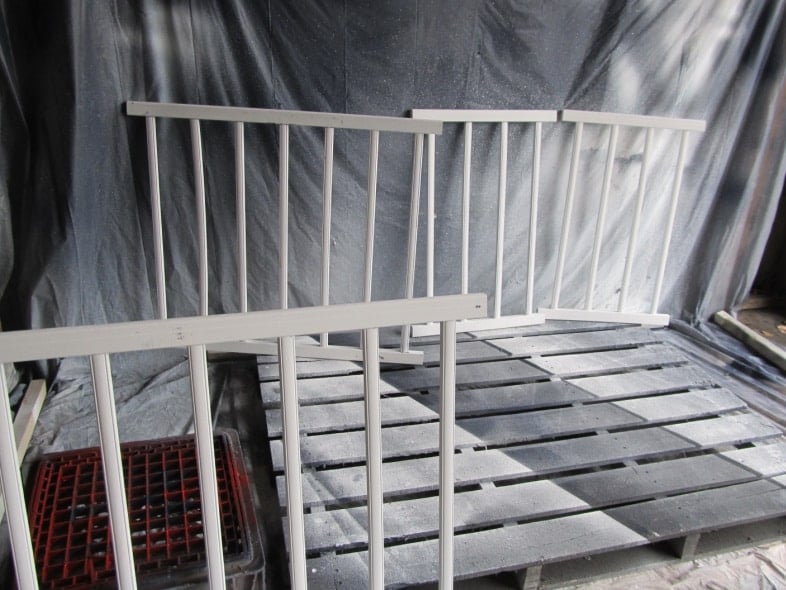 painting crib rails white in a paint booth