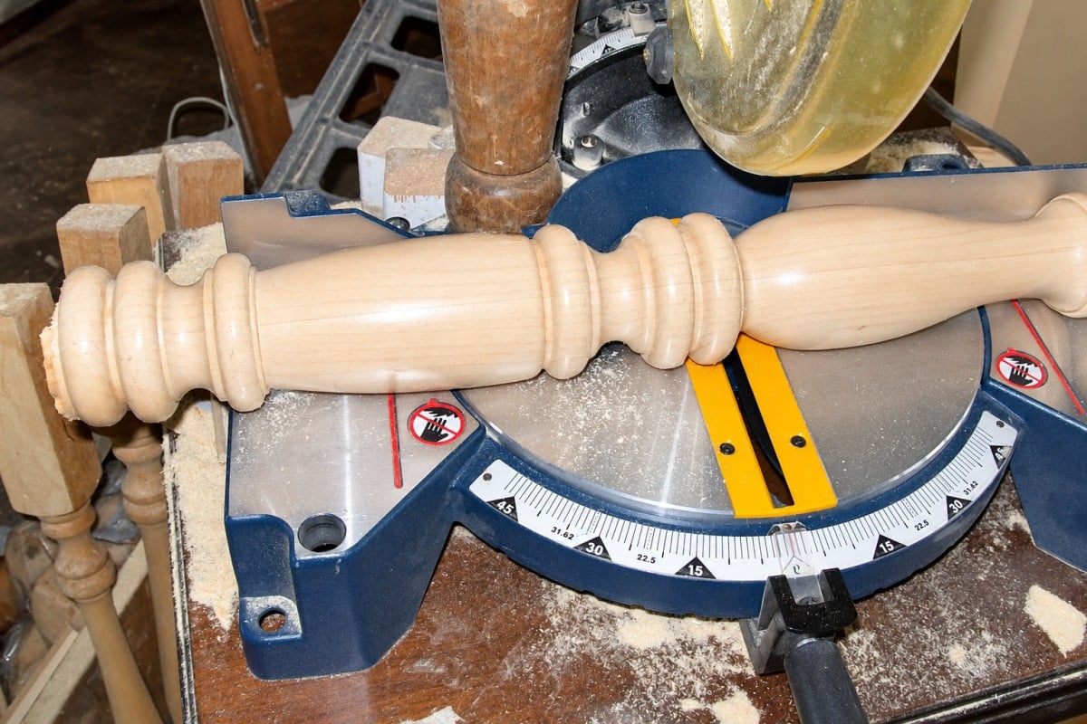 cutting a spindle with a miter saw to make a DIY candlestick