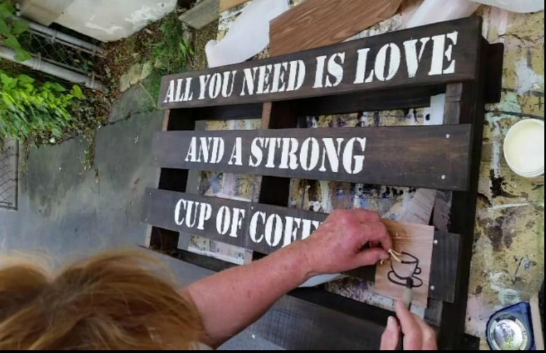 woman removing inside of stencil before painting