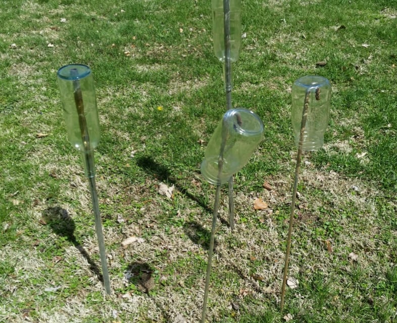 clear wine bottles on rods ready to paint