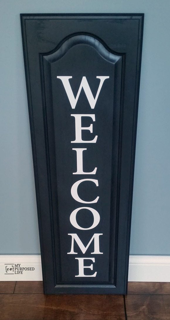 My Repurposed Life black and white WELCOME sign using an old cabinet door and vinyl