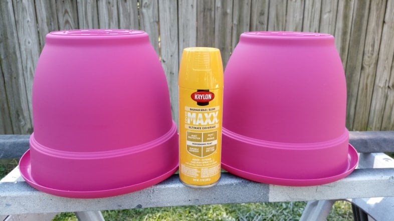 pink flower pots with a yellow can of spray paint