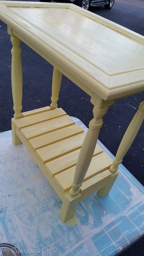 small yellow side table made out of a cabinet door, spindles and scrap wood