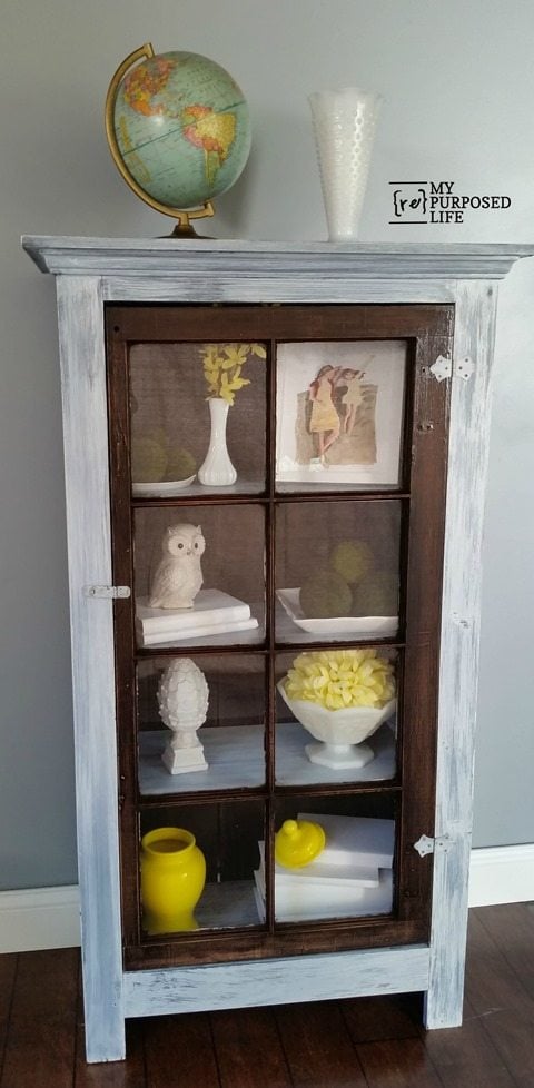 tall cupboard using an old window as a door