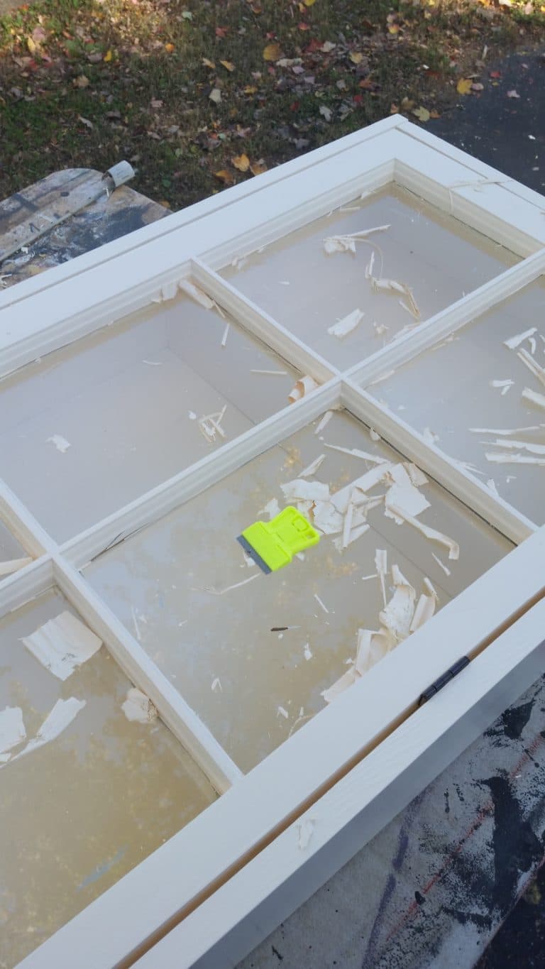 scraping paint from window glass