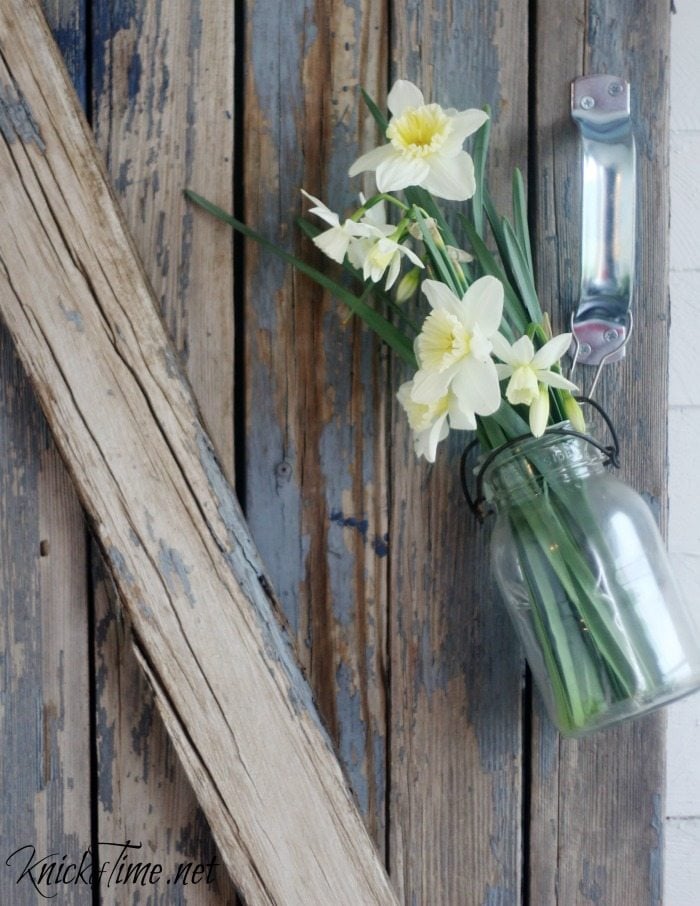 flowers in mason jar on barn gate