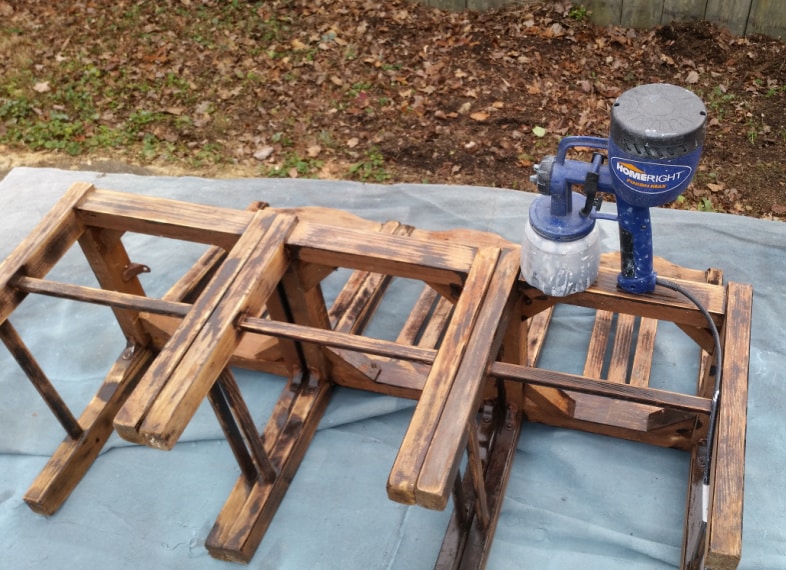 paint sprayer resting on a three chair bench