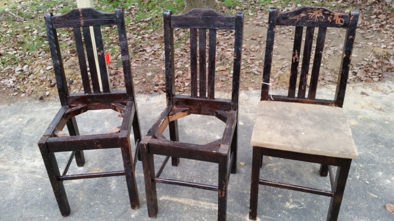 three beat up kitchen chairs