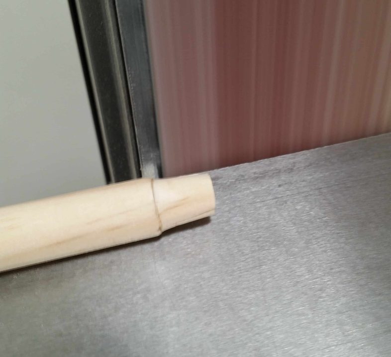 belt sander sanding a dowel rod