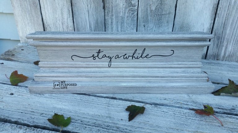 pretty wooden handmade sign with the words "stay awhile"