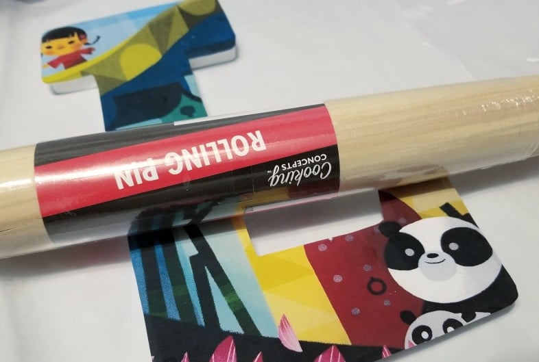 a dollar store rolling pin laying on wooden decoupaged letter