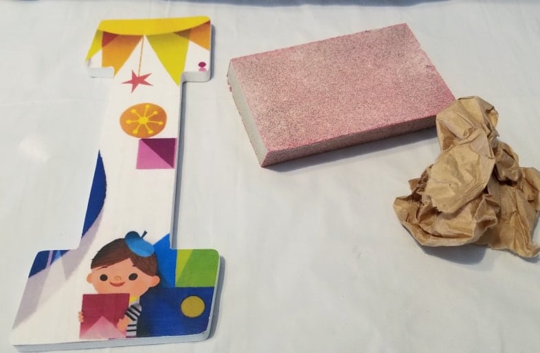 colorful paper on wooden I with sandpaper and brown craft paper