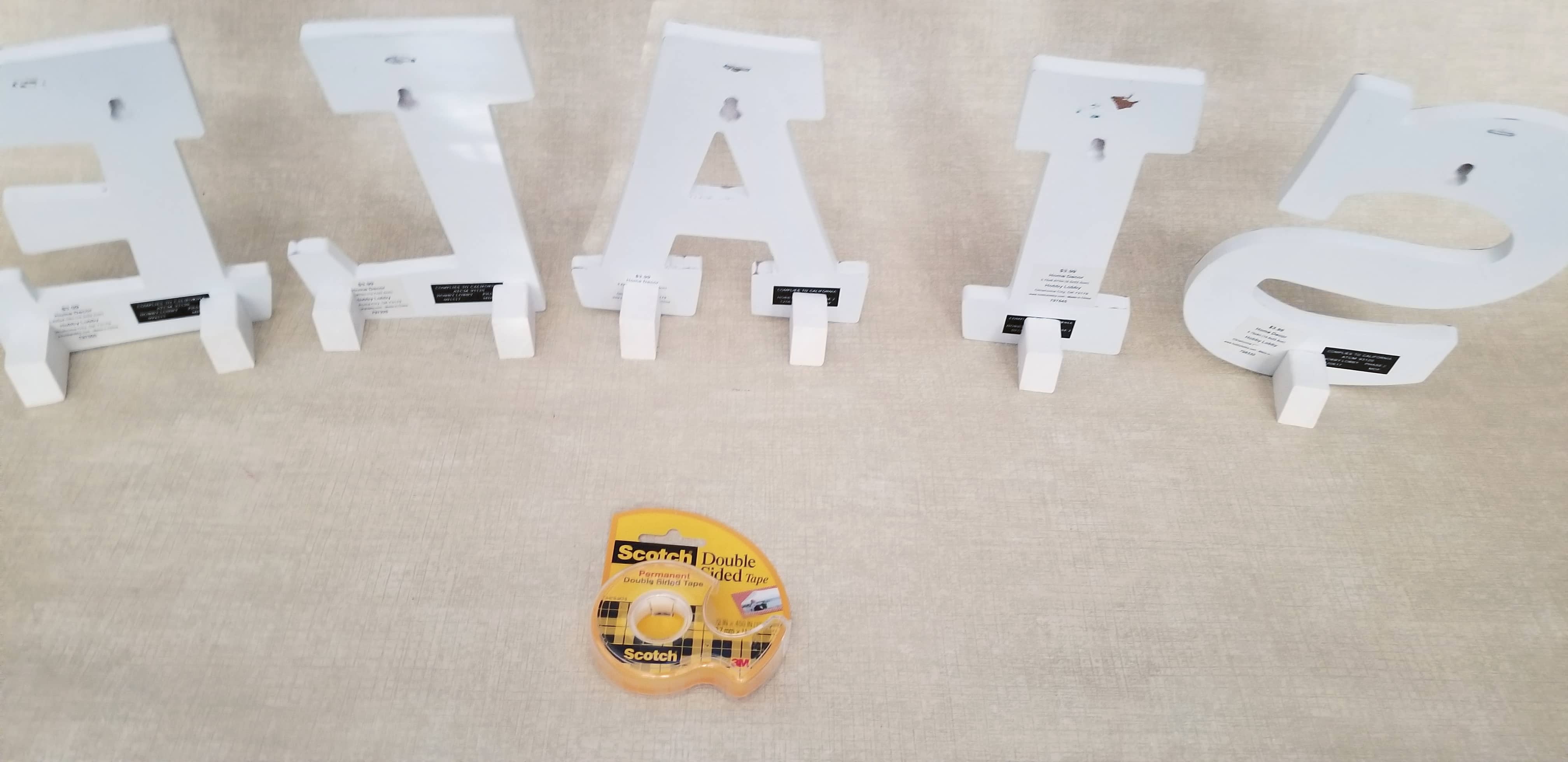 letters being held upright by small wooden easels
