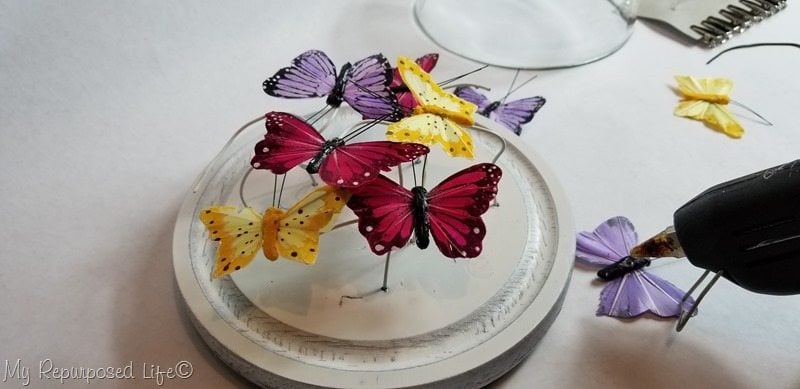 secure butterflies to wire with hot glue
