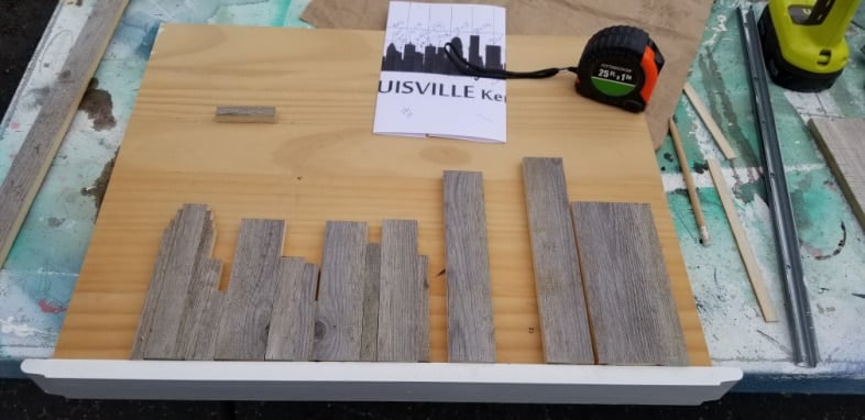 cutting small boards to make rustic skyline art