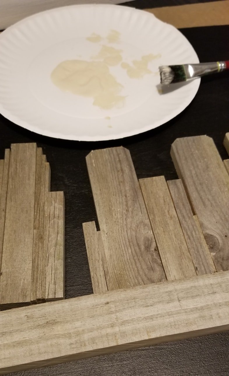 cut weathered fence board on miter saw to make rustic frame