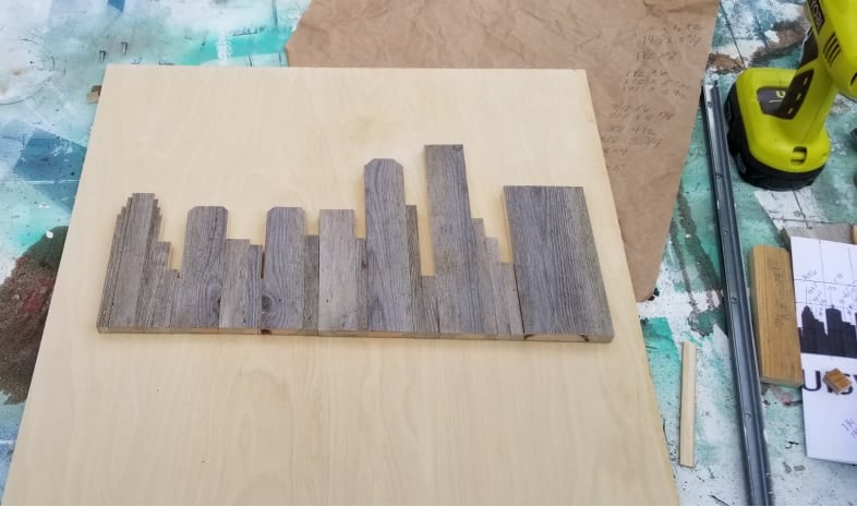 rustic skyline artwork placed on plywood