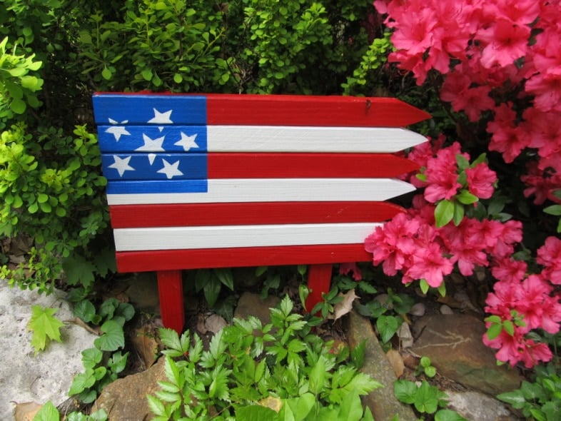 small garden flag in a flower bed
