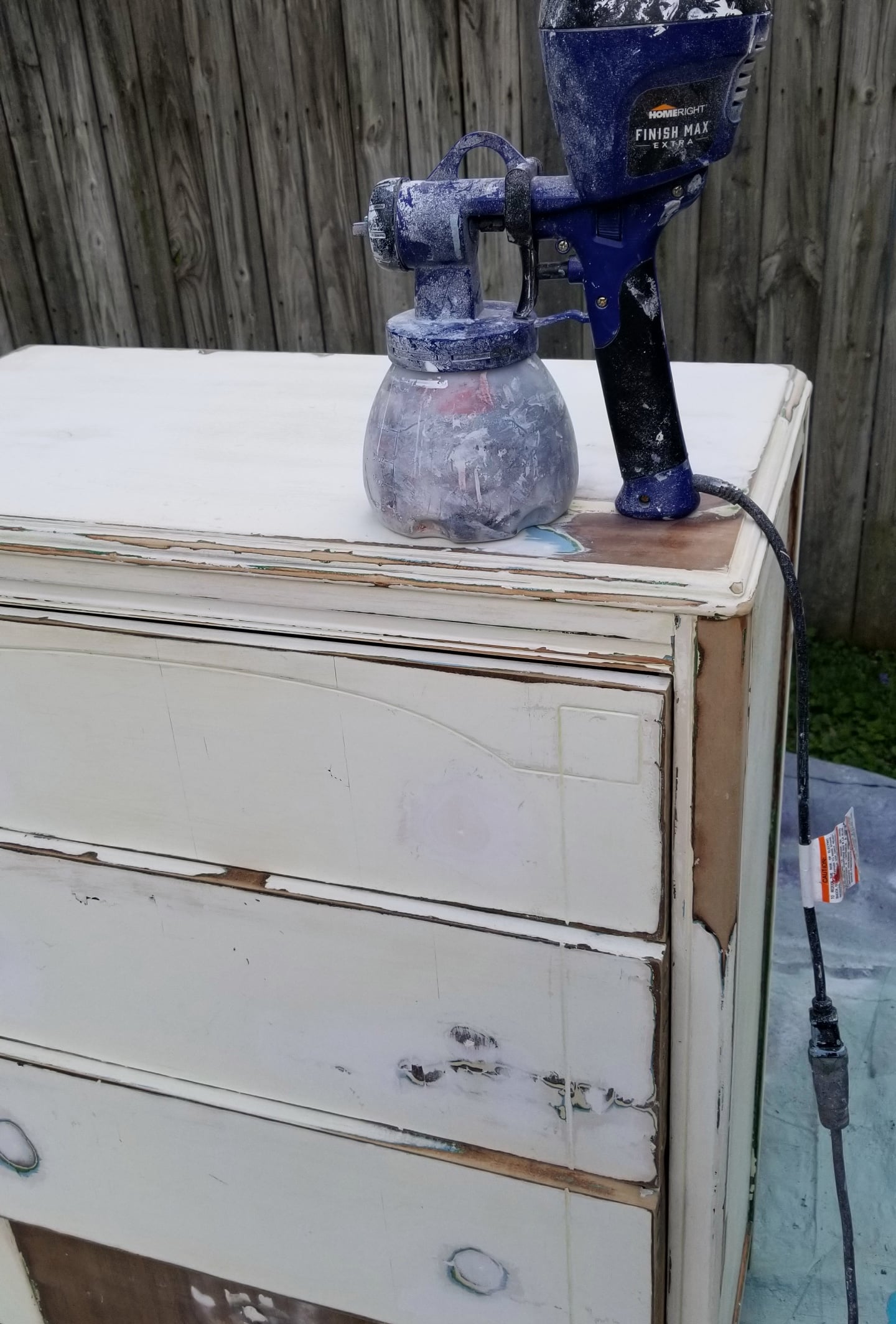 super finish max extra paint sprayer resting atop a chest of drawers