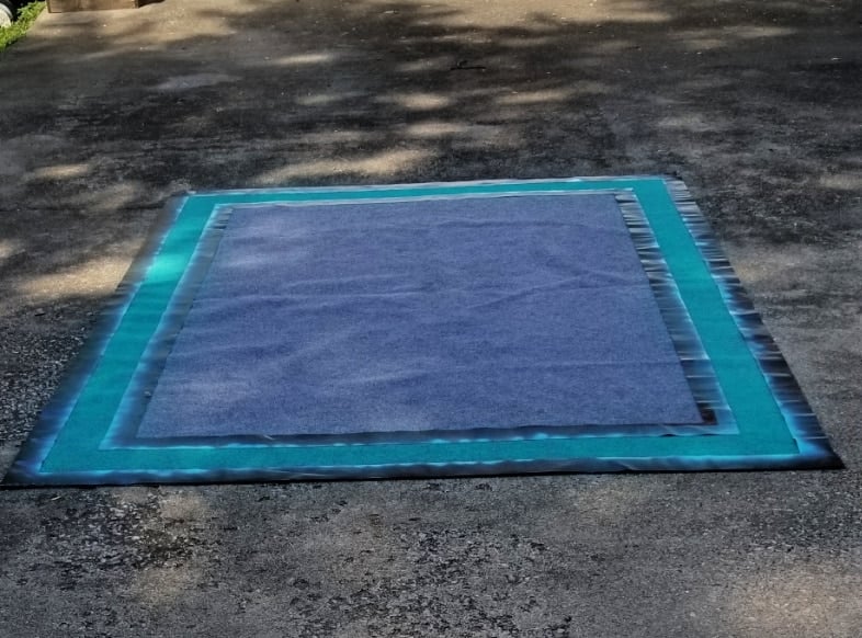 aqua spray paint on a gray rug