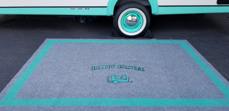 happy camper rug in front of a camper
