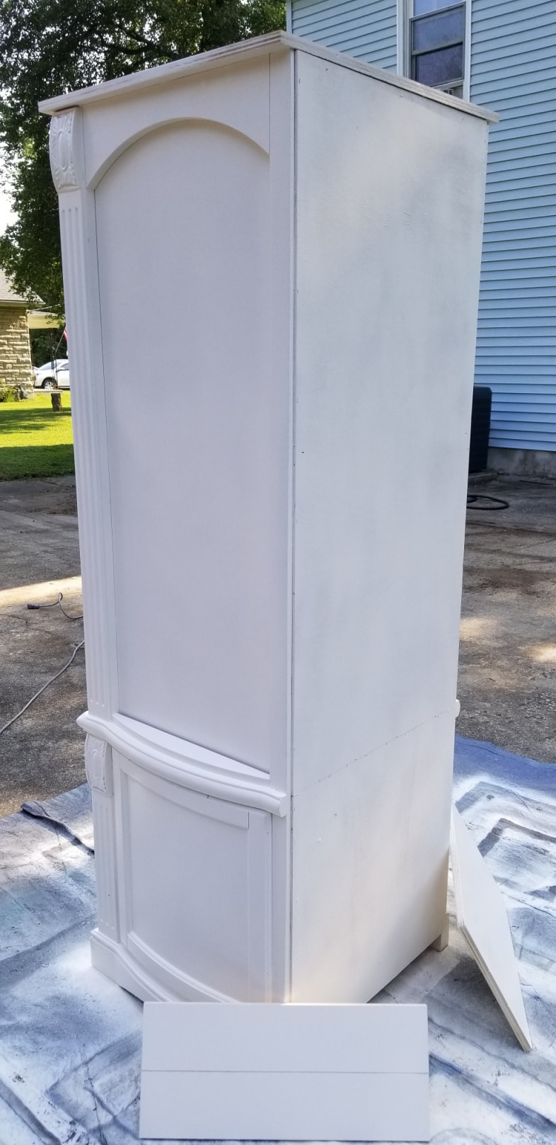 white armoire resting on a drop cloth