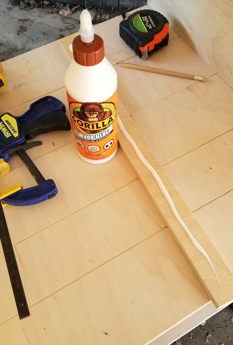 wood glue and clamp on plywood shelf