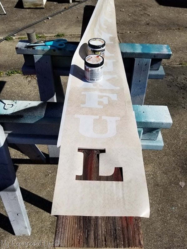 apply contact paper stencil to long board for thankful sign