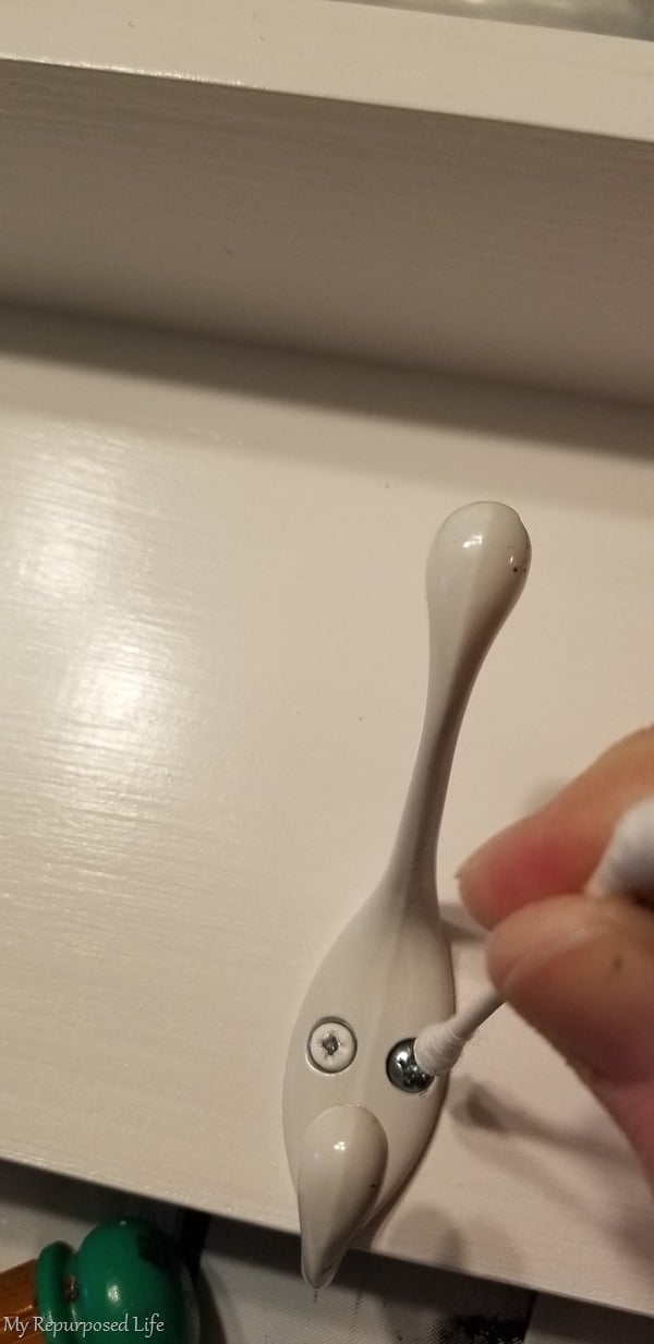 dab white paint on screw head with cotton swab