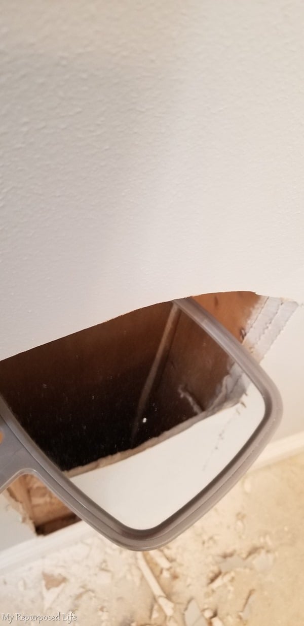hand mirror to inspect inside drywall