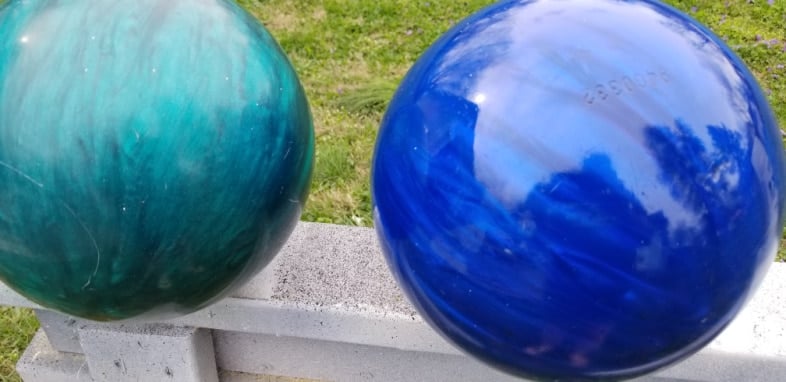 dull aqua bowling ball and shiny bright blue bowling ball