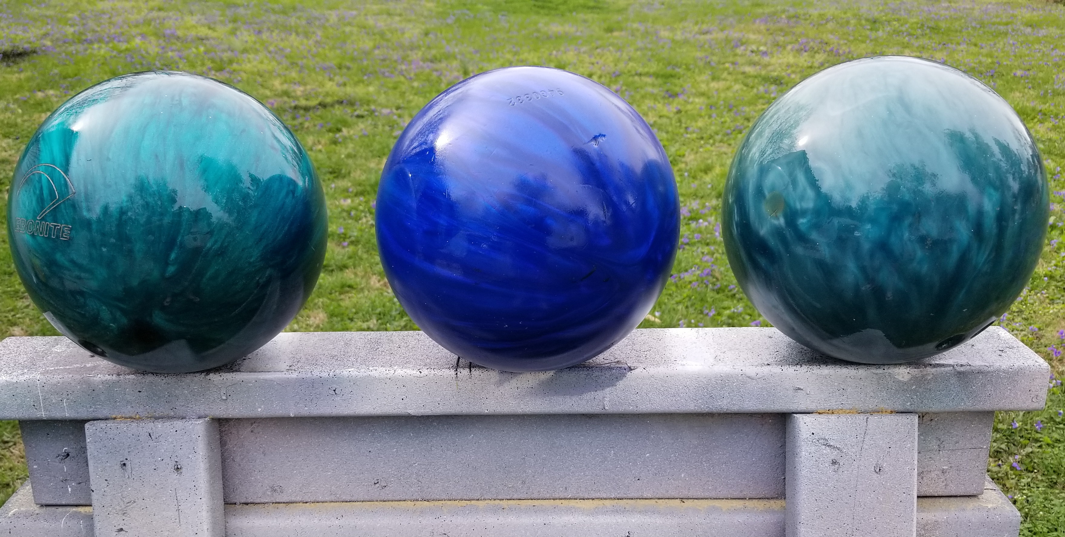 three shiny DIY gazing balls sitting on a sawhorse