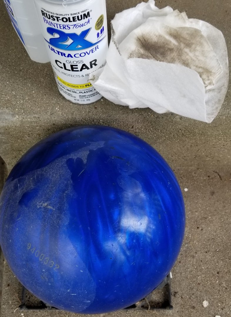 cleaning a blue bowling ball with alcohol