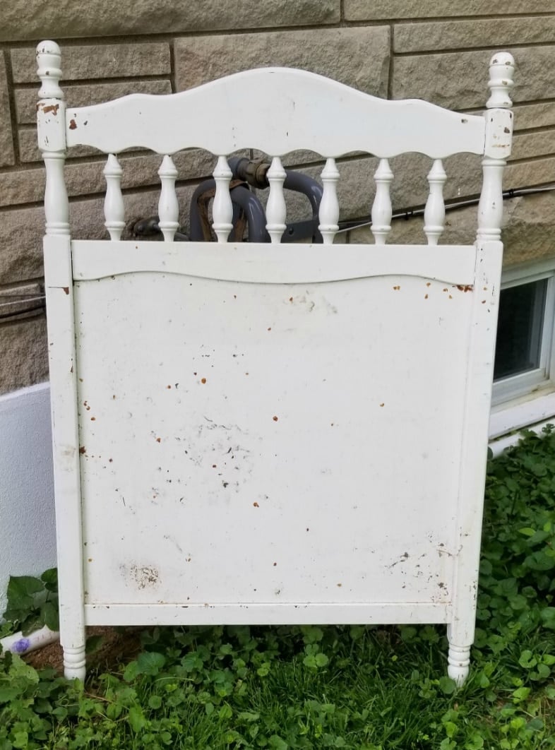 vintage crib repurposed as a faux garden gate gas meter cover