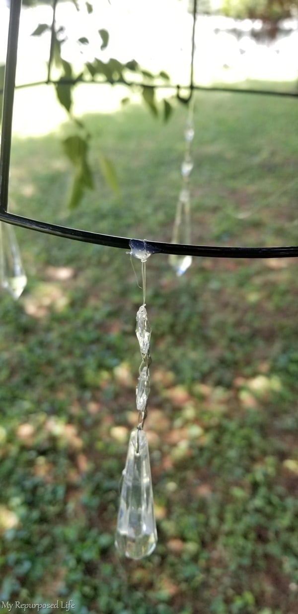 closeup of hot glue holding prism on wire basket solar light