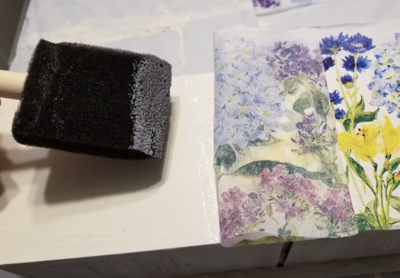 foam brush applying mod podge to apply napkin