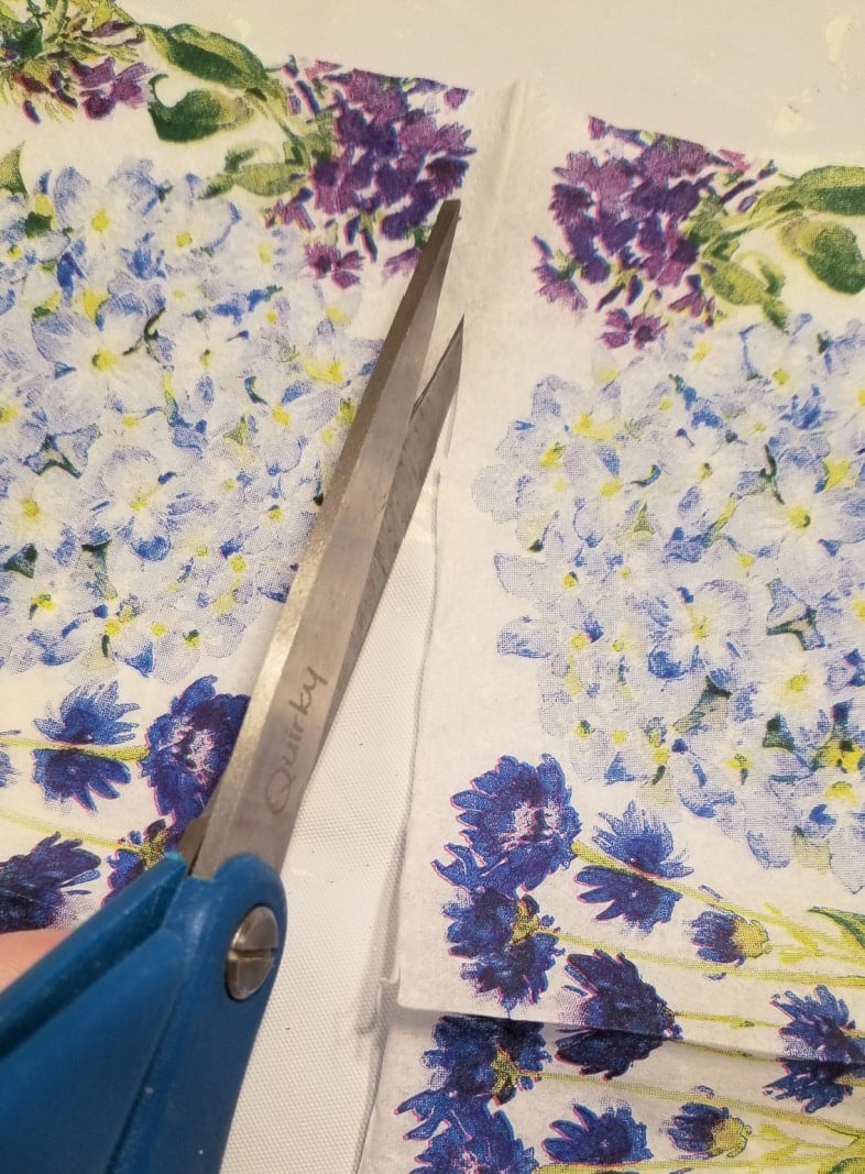 napkin being cut in half with scissors