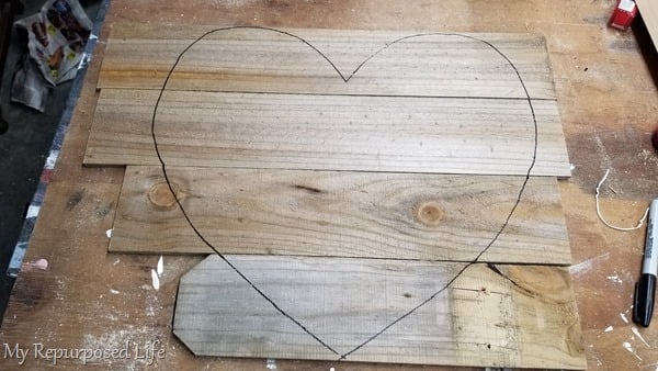 trace paper heart pattern on reclaimed wood fencing