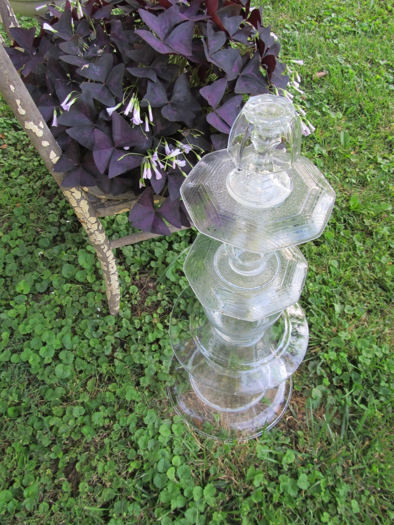 clear glass totem sitting beside a planter chair