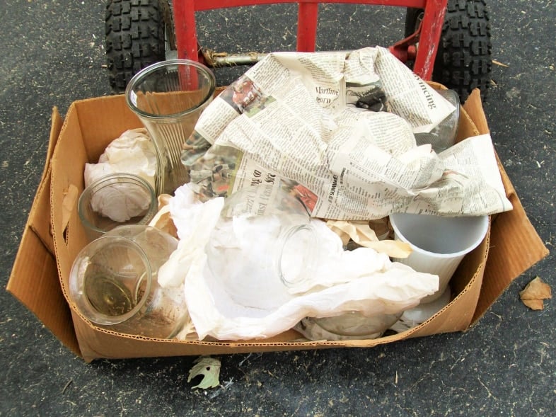 dirty glassware in a cardboard box