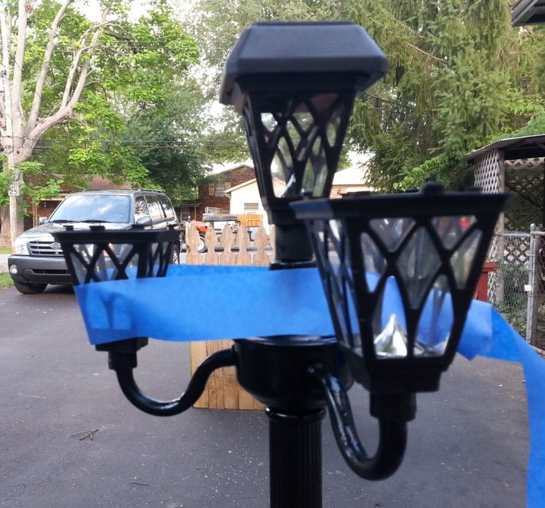 blue painters tape used to hold solar lights in place while the adhesive sets up