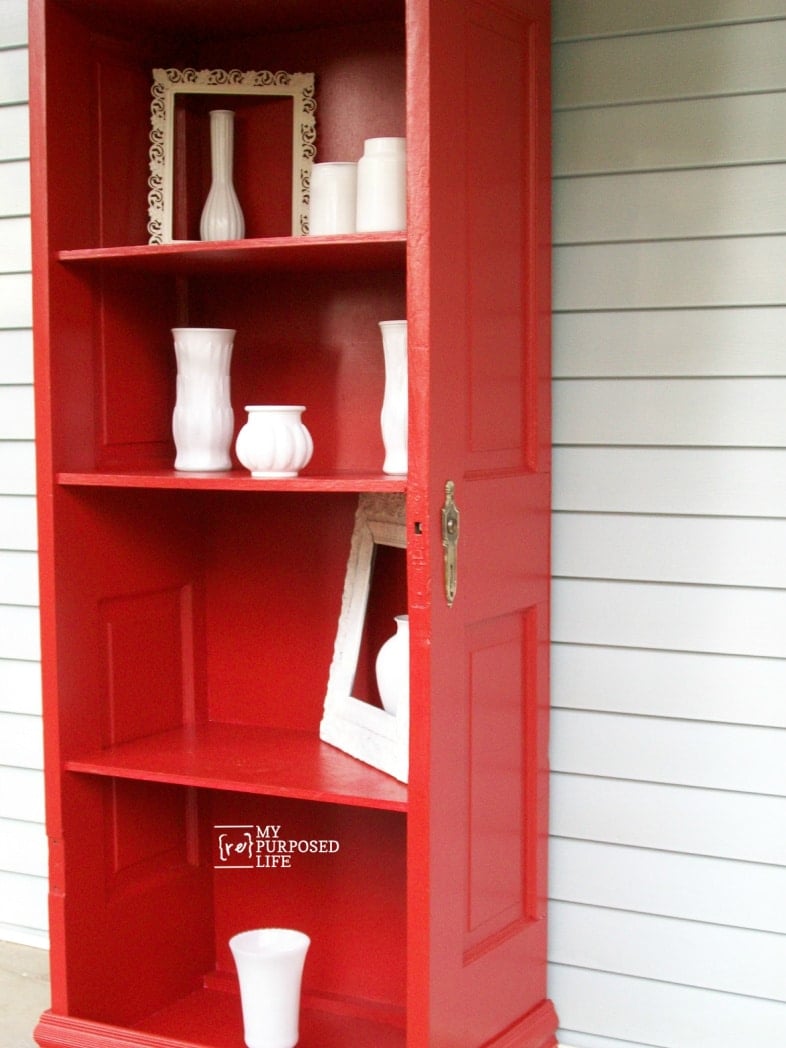 red door bookshelf with white glassware