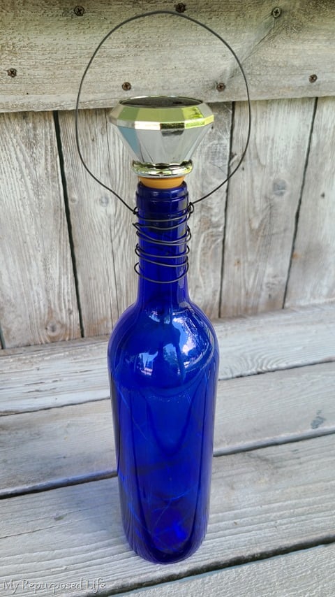 blue wine bottle with solar lights and wire handle